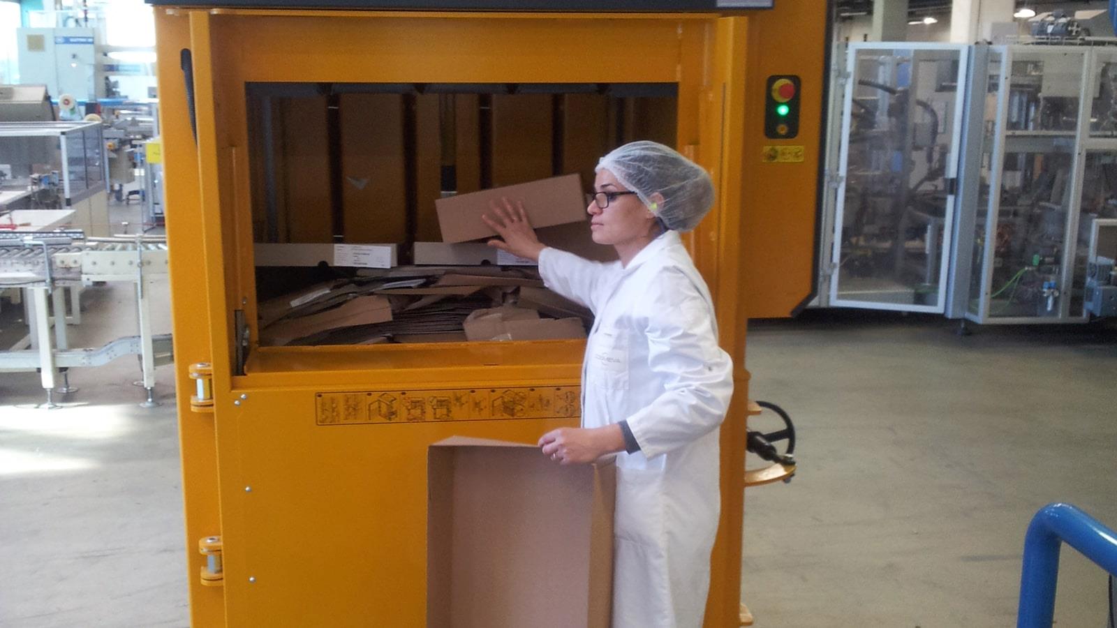 Employée chargeant les déchets carton dans une presse Bramidan