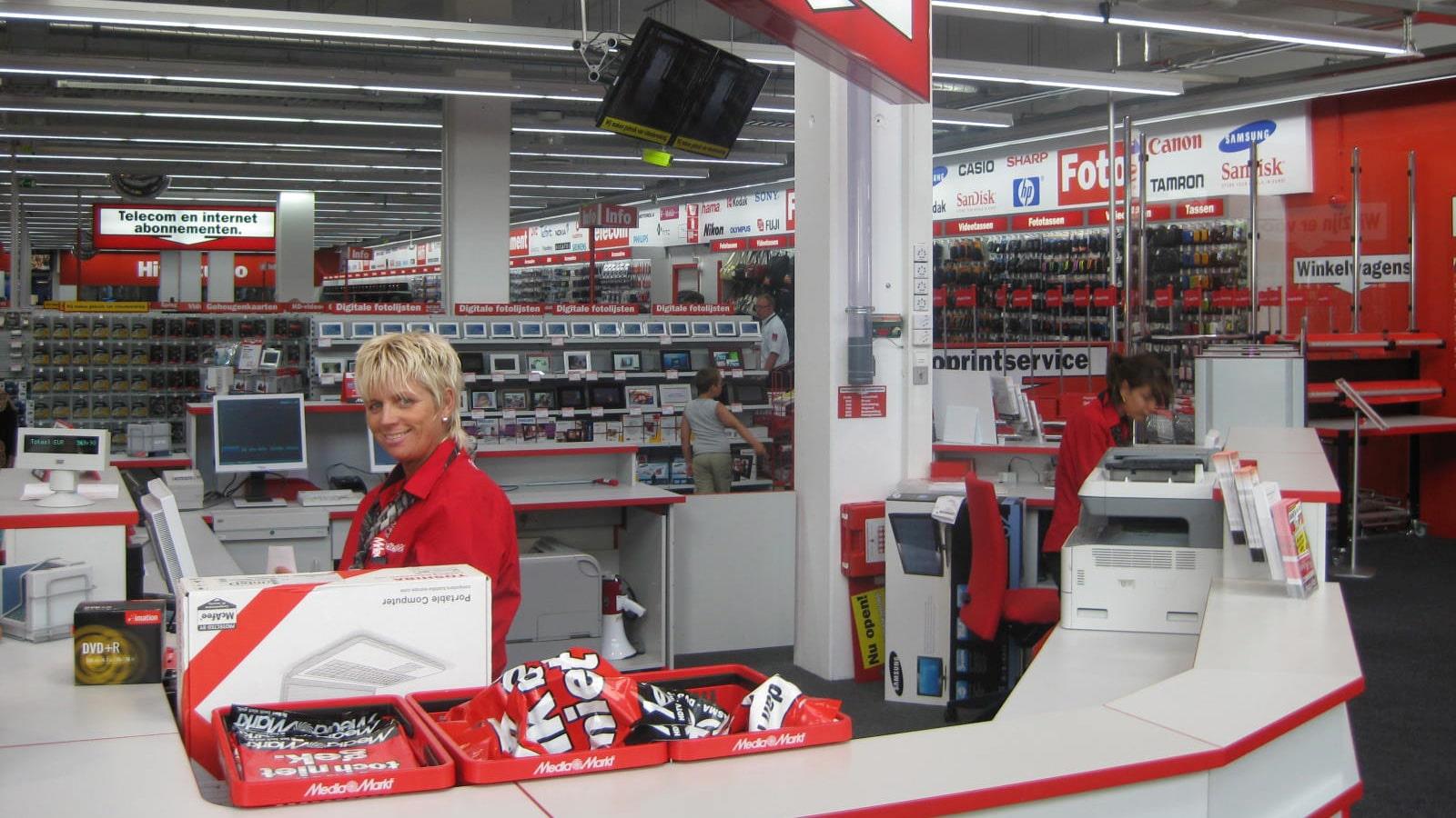 Caissière en uniforme rouge dans un magasin Media Markt