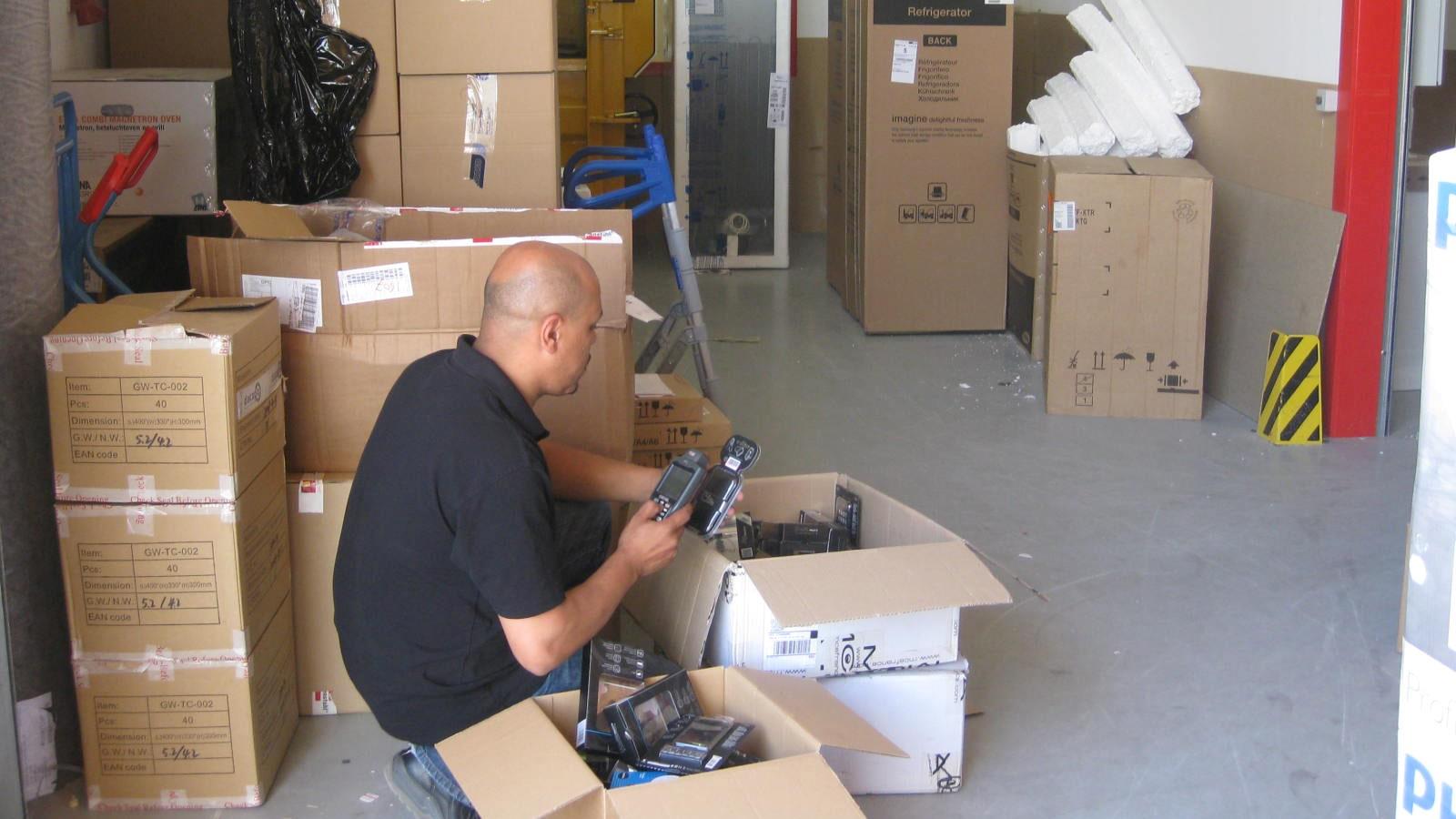 Un employé scanne puis enregistre l’arrivage de marchandise dans un entrepôt Media Markt