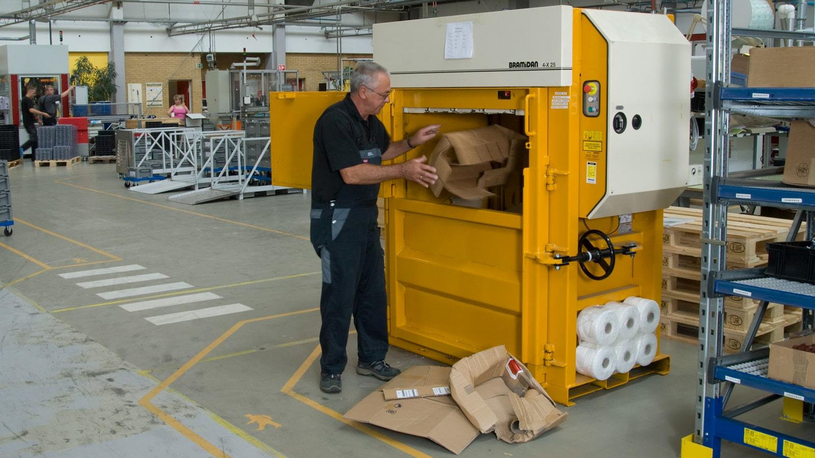 Un employé compacte les déchets carton dans l’usine Sauer-Danfoss