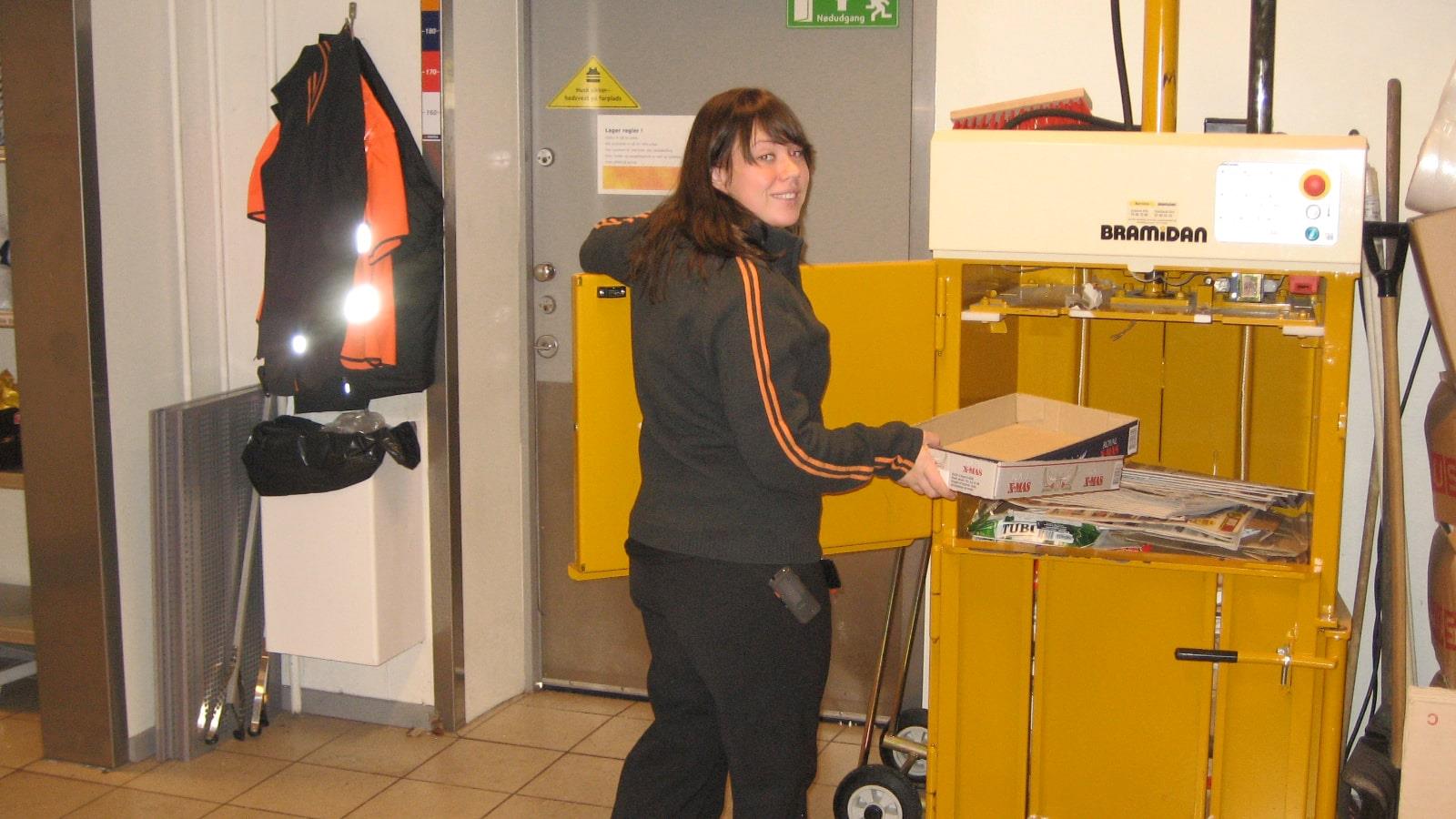 Jeune femme chargeant du carton dans une petite presse B3