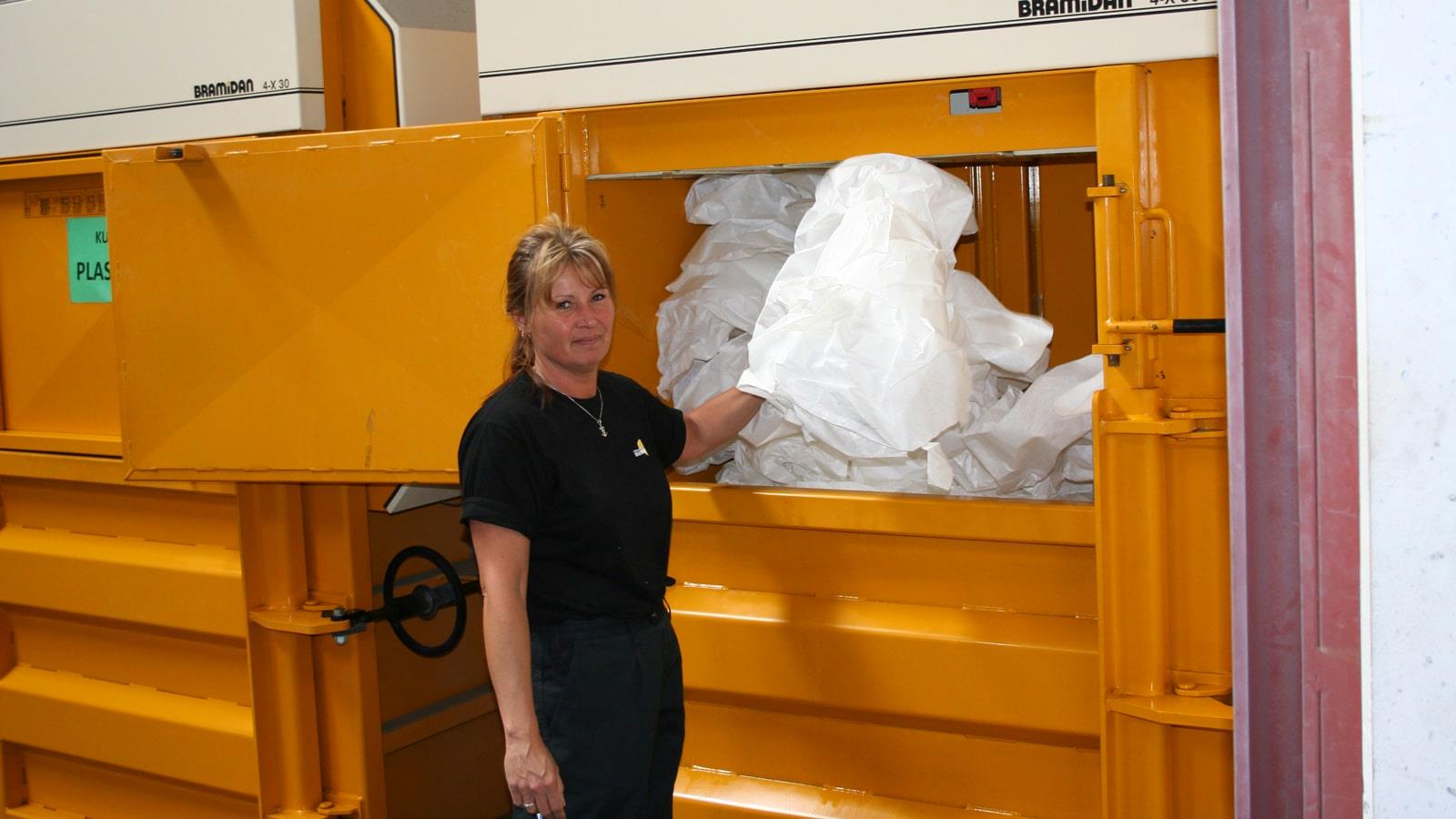 Une employée chez Sunarc élimine les plastiques dans une presse